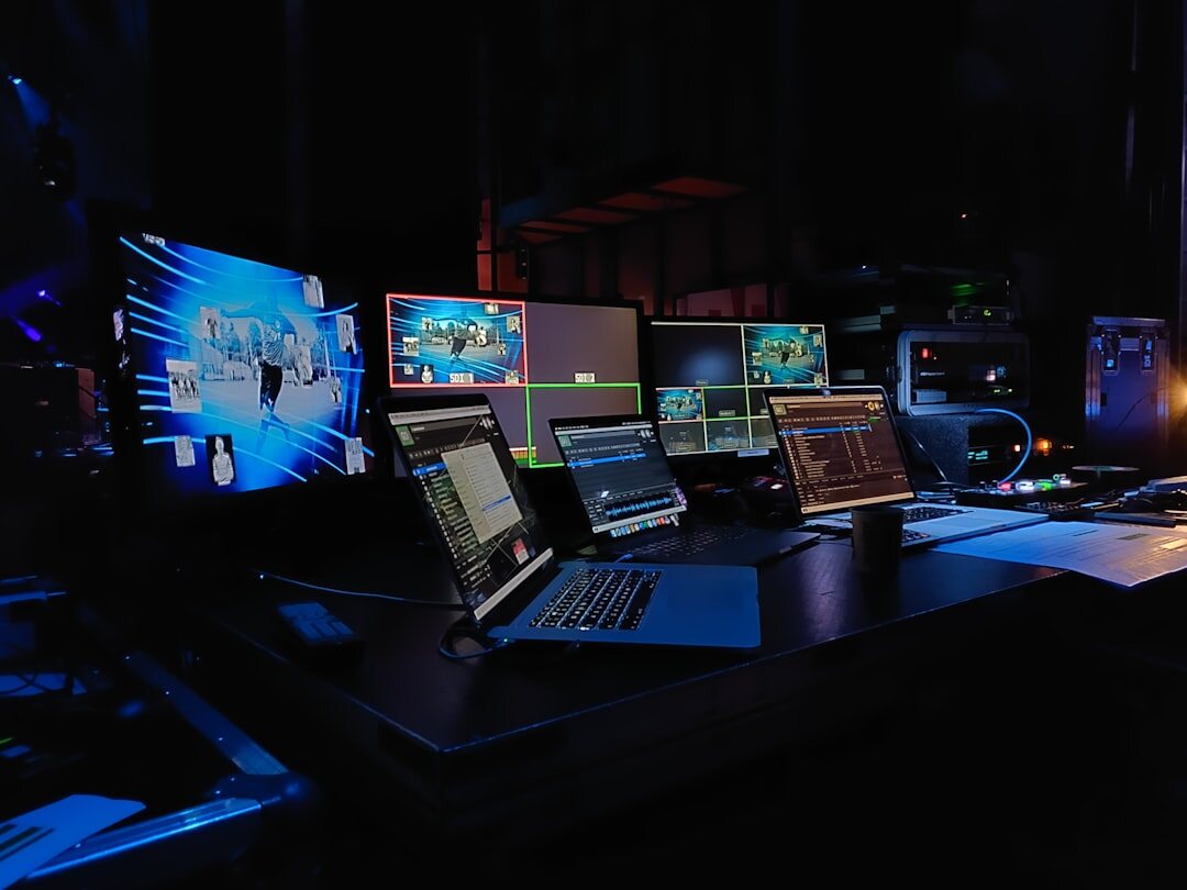 Professional video editing workstation with multiple monitors showing color grading timeline