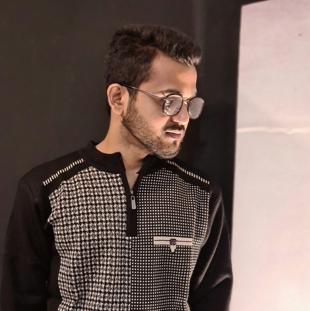 Professional Turkish male video editor with glasses headshot